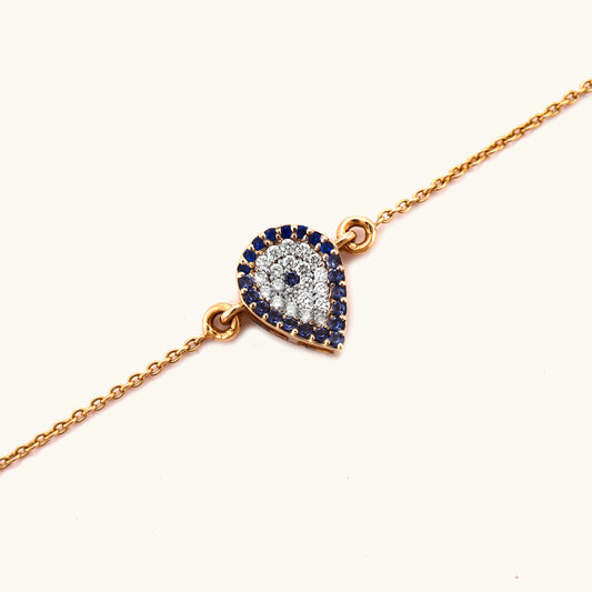 Discover everyday elegance with our 18kt Evil Eye Drop Bracelet from the spring edit. Featuring a symbolic evil eye design adorned with diamonds, this meaningful bracelet makes a perfect protective gift for her, priced under Rs. 30,000. Crafted with care for daily wear, this accessory seamlessly elevates any work or casual outfit, adding a touch of luxurious style.