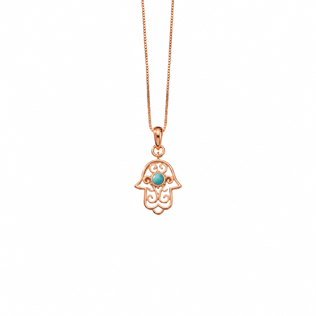 Gold hamsa hand pendant with white enamel detailing and a turquoise stone center. Perfect minimal gift for her under Rs. 15,000