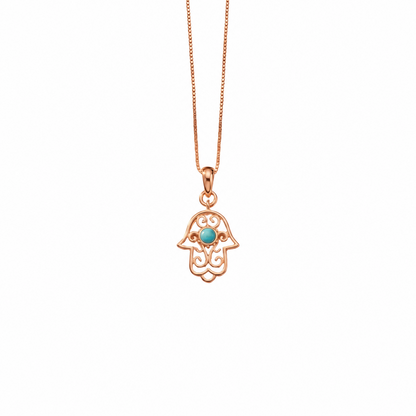 Gold hamsa hand pendant with white enamel detailing and a turquoise stone center. Perfect minimal gift for her under Rs. 15,000