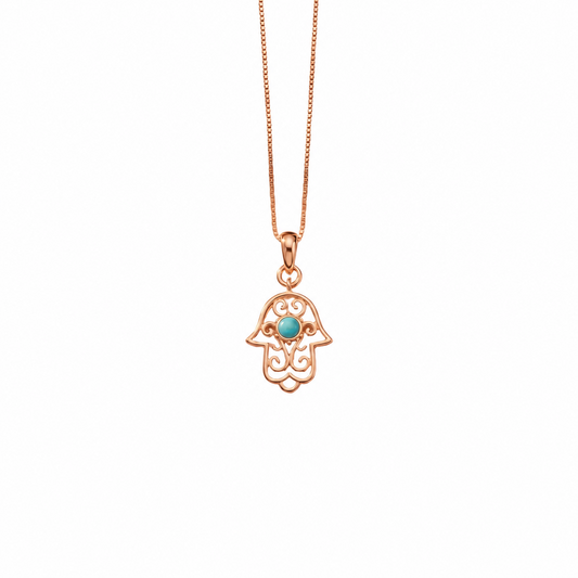 Gold hamsa hand pendant with white enamel detailing and a turquoise stone center. Perfect minimal gift for her under Rs. 15,000
