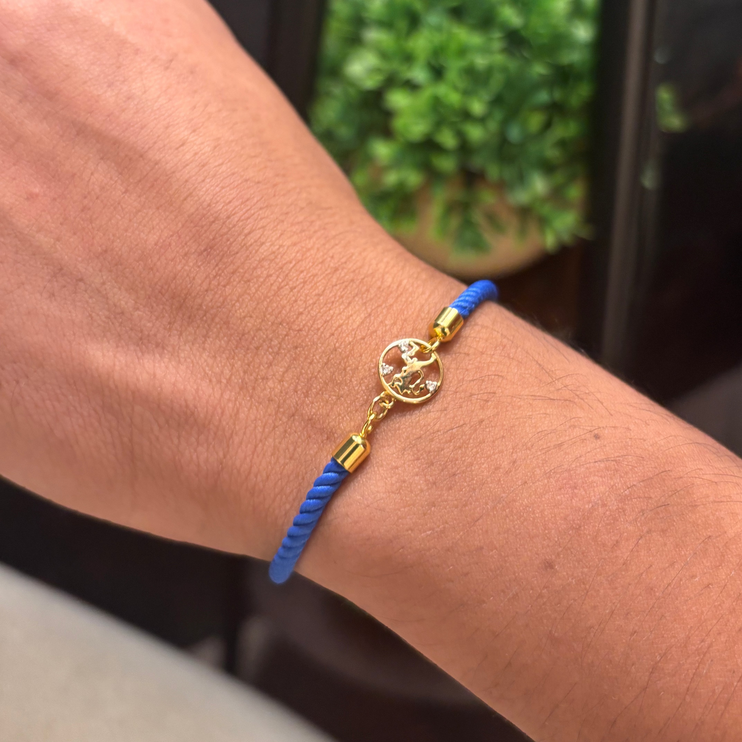 Blue rope men's bracelet with an 18kt gold Hanuman Ji pendant and diamond accents, on white background. Gift for him under Rs. 15,000