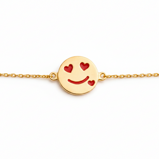 Gold bracelet with a round disc charm featuring a smiley face and red heart eyes. Cute gold gifts for kids under Rs. 40,000
