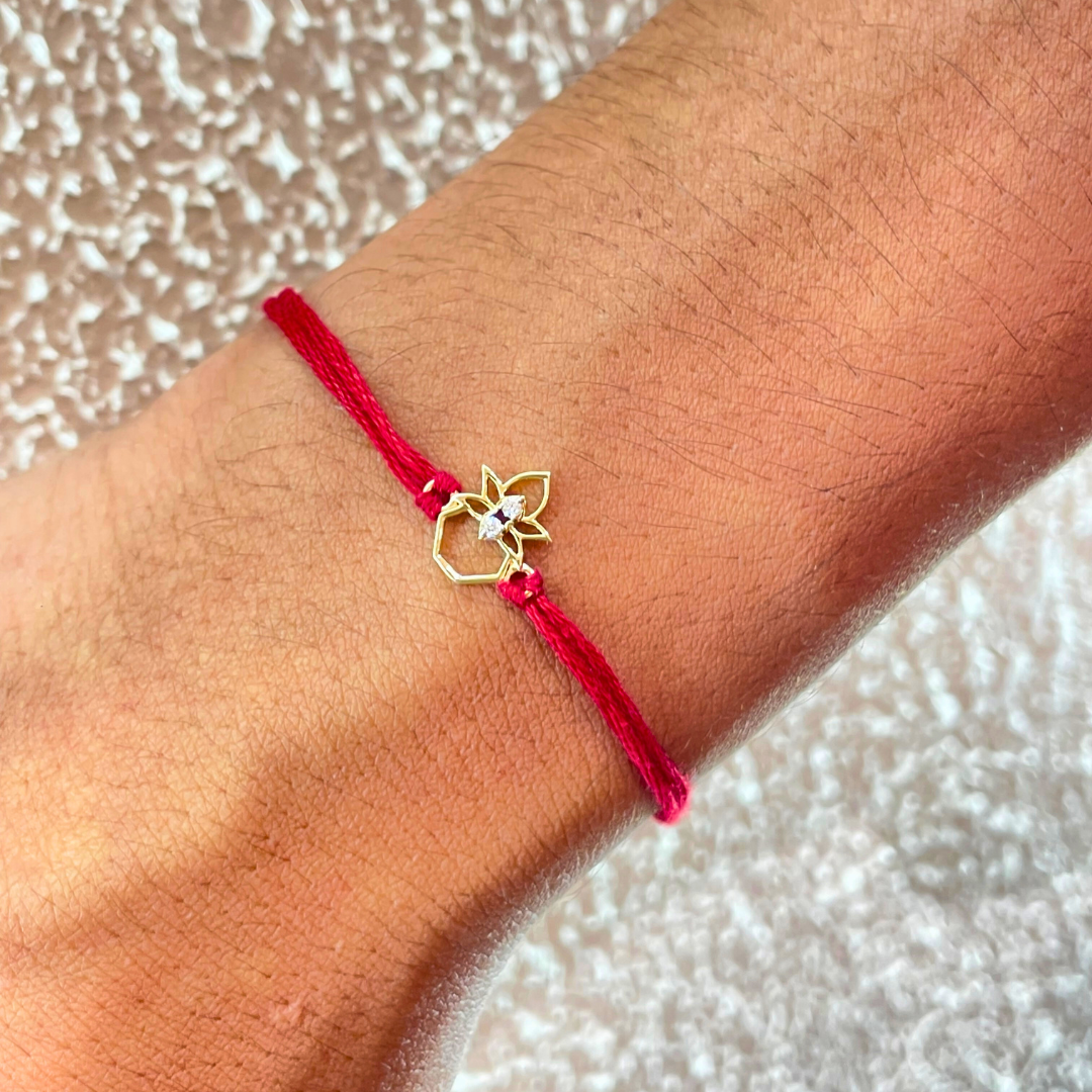 Kalash Rakhi in 18kt gold with a natural diamond, tied on red thread—BIS hallmarked, a Rakhi cum pendant symbolizing blessings and tradition under Rs. 15,000!