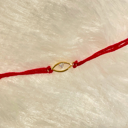 Evil Eye Rakhi in 18kt gold with a natural diamond, tied on red thread—symbolizing protection and style. A Rakhi cum pendant under ₹15K from Caratly. 