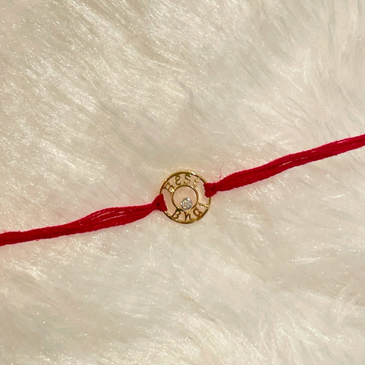 Best Bhai Rakhi in 18kt gold with a natural diamond, featuring an engraved gold charm on red thread—crafted for meaningful Raksha Bandhan gifting under Rs. 15,000!