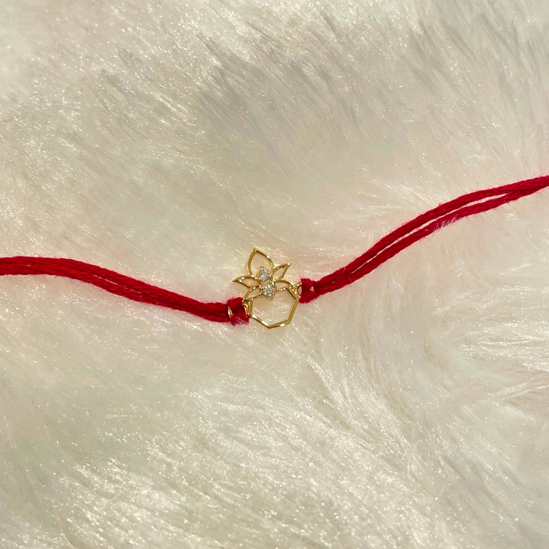 Kalash Rakhi in 18kt gold with a natural diamond, tied on red thread—BIS hallmarked, a Rakhi cum pendant symbolizing blessings and tradition under Rs. 15,000!
