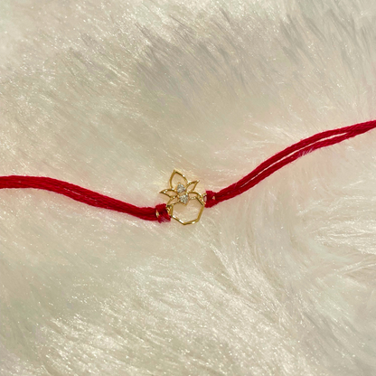 Kalash Rakhi in 18kt gold with a natural diamond, tied on red thread—BIS hallmarked, a Rakhi cum pendant symbolizing blessings and tradition under Rs. 15,000!