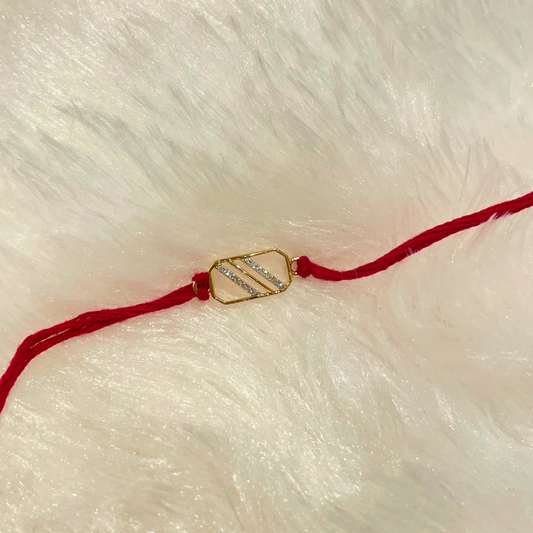 Rectangle-shaped gold rakhi with natural diamond, crafted in 18kt gold and tied with red thread—perfect for elegant Raksha Bandhan gifting under Rs. 15,000!