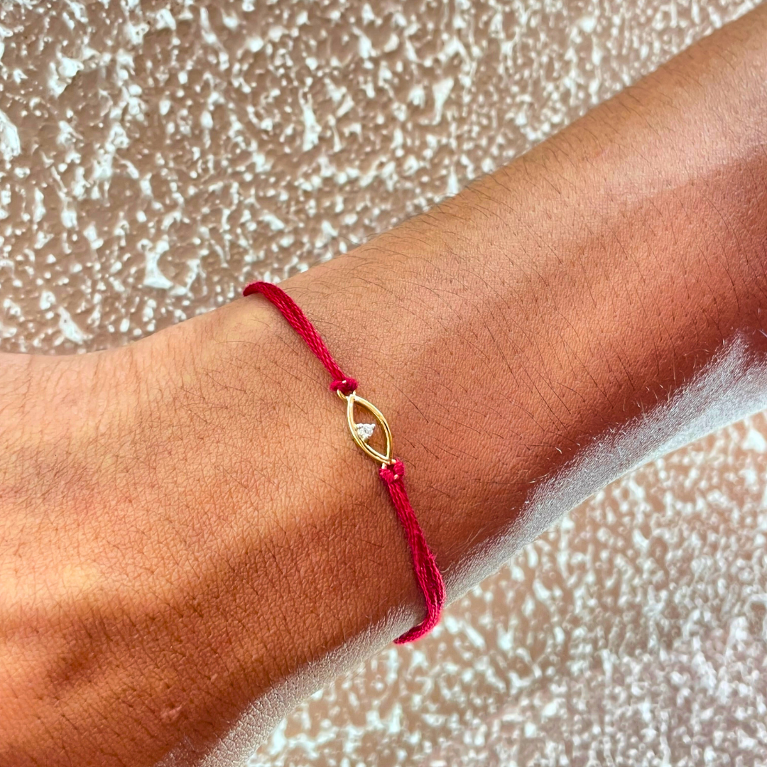 Evil Eye Rakhi in 18kt gold with a natural diamond, tied on red thread—symbolizing protection and style. A Rakhi cum pendant under ₹15K from Caratly. 