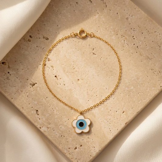 Delicate gold chain bracelet with a white flower-shaped evil eye charm under Rs. 25,000