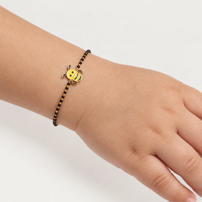 Black bead bracelet with a gold clasp and a yellow enamel bee charm. Cute and minimal gifts for kids under Rs. 40,000