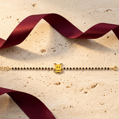 Black bead bracelet with a gold clasp and a yellow enamel bee charm. Cute and minimal gifts for kids under Rs. 40,000