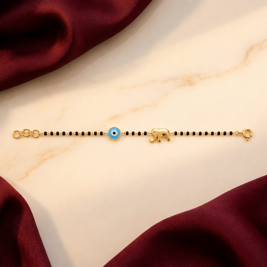 Black bead bracelet with a blue evil eye bead and a gold elephant charm. Minimal and cute gift for kids under Rs. 50,000