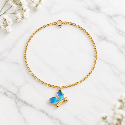 Gold chain bracelet with an enamel blue butterfly charm dangling priced under Rs. 30,000.