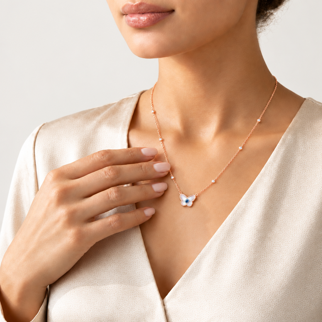 Rose gold chain necklace with a butterfly-shaped evil eye pendant and crystal bead stations. Luxe gifts for her under Rs. 60,000
