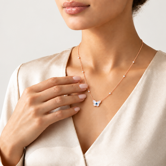 Rose gold chain necklace with a butterfly-shaped evil eye pendant and crystal bead stations. Luxe gifts for her under Rs. 60,000