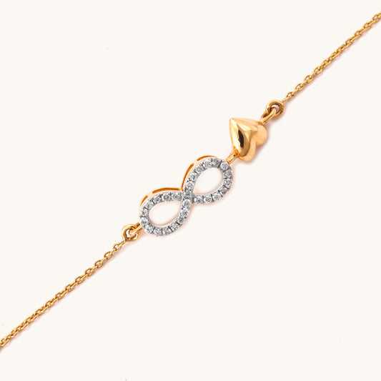 Caratly 18kt gold Infinity Love Bracelet featuring a diamond pave infinity loop intertwined with a small polished solid gold heart charm. Minimal Everyday Wear Gift for her under Rs. 40,000