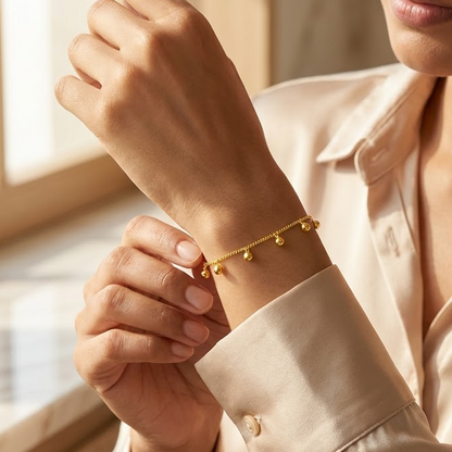 Gold chain bracelet with five small dangling gold ball charms priced under Rs. 60,000