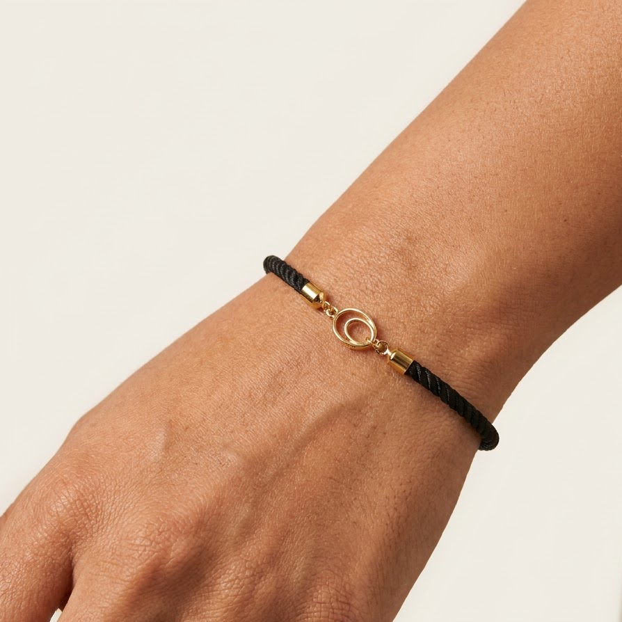 Black rope men's gold bracelet featuring an 18kt gold circle ring charm motif. An affordable gold gift for him under Rs. 15,000