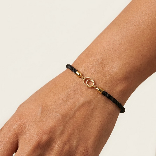 Black rope men's gold bracelet featuring an 18kt gold circle ring charm motif. An affordable gold gift for him under Rs. 15,000