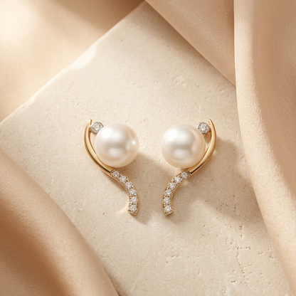 Gold curved earrings with a white pearl at the top and a pave diamond lower arc. Luxe gifts for her under Rs. 60,000