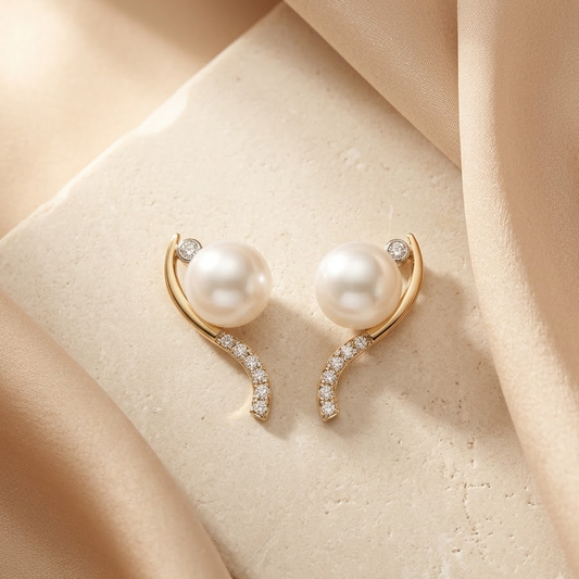 Gold curved earrings with a white pearl at the top and a pave diamond lower arc. Luxe gifts for her under Rs. 60,000