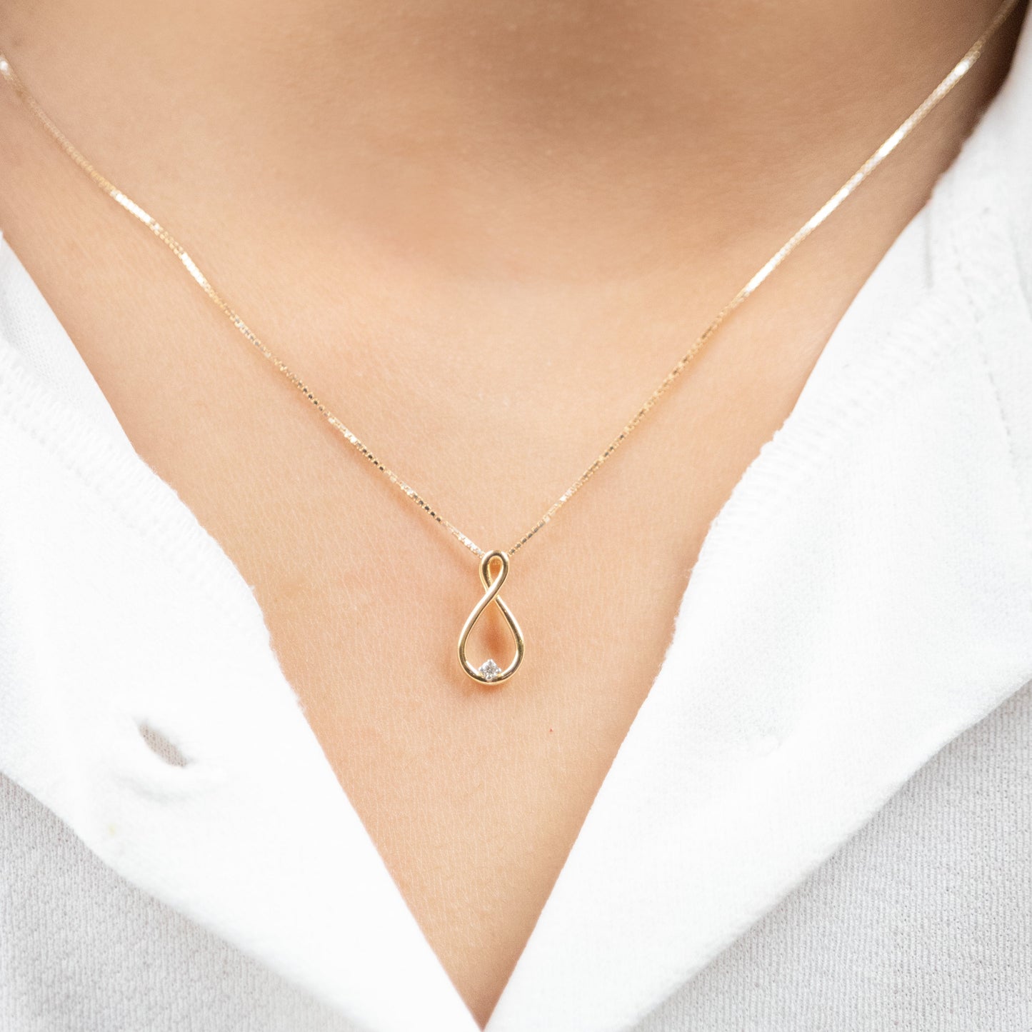 Caratly 18kt gold Infinity Diamond Pendant with 0.02ct diamond accent and vertical twisted loop design under Rs. 15,000