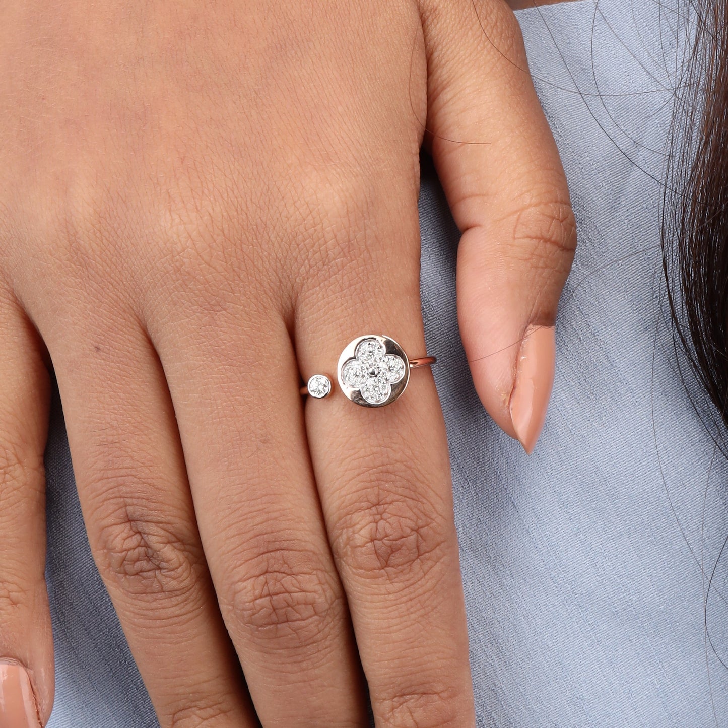 Caratly 18kt gold Flower Diamond Ring featuring an open bypass design with a diamond clover shape on one end and a small round bezel diamond on the other.
