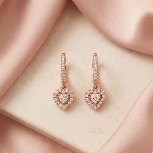 Rose gold huggie hoop earrings with a dangling pave diamond heart charm. Luxe and elegant gifts under Rs. 80,000