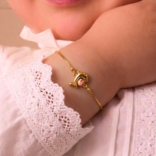 Gold box-chain bracelet with an enamel pink dolphin charm. A cute gift for kids under Rs. 40,000