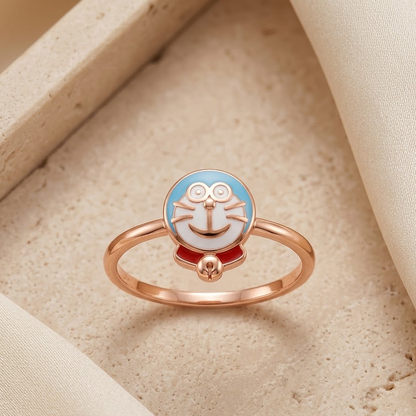 Rose gold ring with a round blue and white cartoon robot cat face charm named as Doraemon. Cute gifts for kids under Rs. 20,000