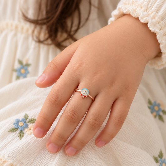 Rose gold ring with a round blue and white cartoon robot cat face charm named as Doraemon. Cute gifts for kids under Rs. 20,000