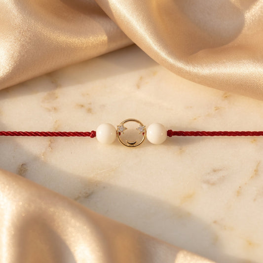 Gold moon and star diamond Rakhi with white beads.
