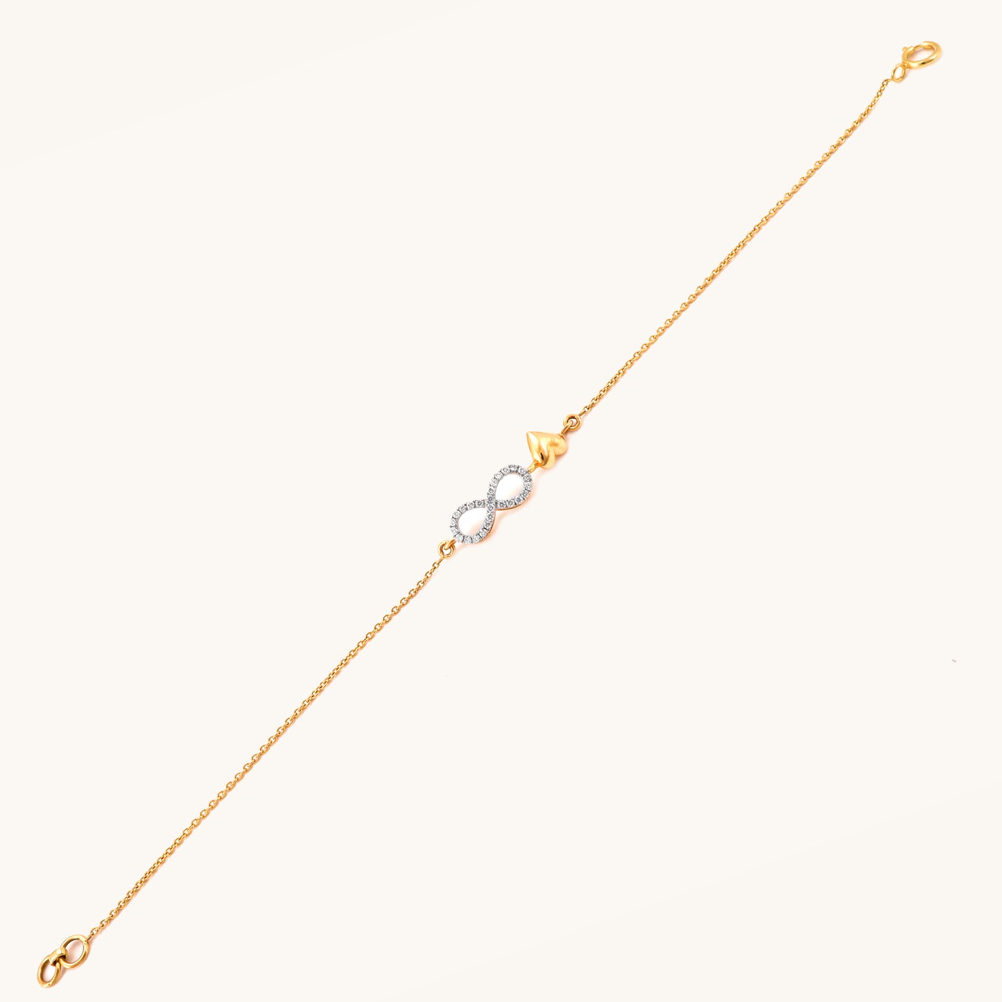 Caratly 18kt gold Infinity Love Bracelet featuring a diamond pave infinity loop intertwined with a small polished solid gold heart charm. Minimal Everyday Wear Gift for her under Rs. 40,000