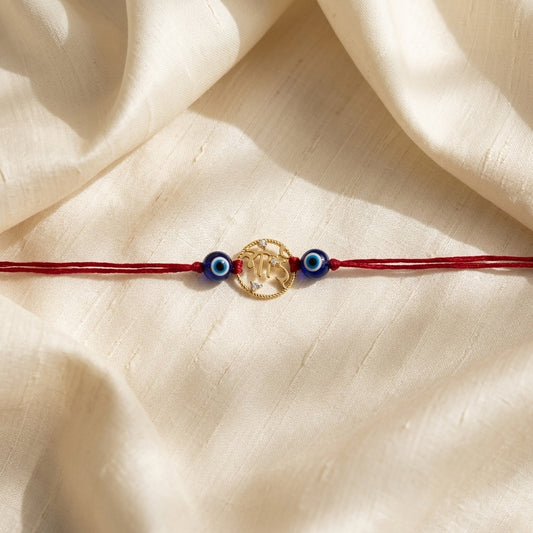 Gold Bhai Rakhi with Evil Eye beads on red thread.