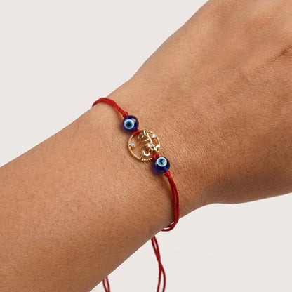 Gold Bhai Rakhi with Evil Eye beads on red thread.
