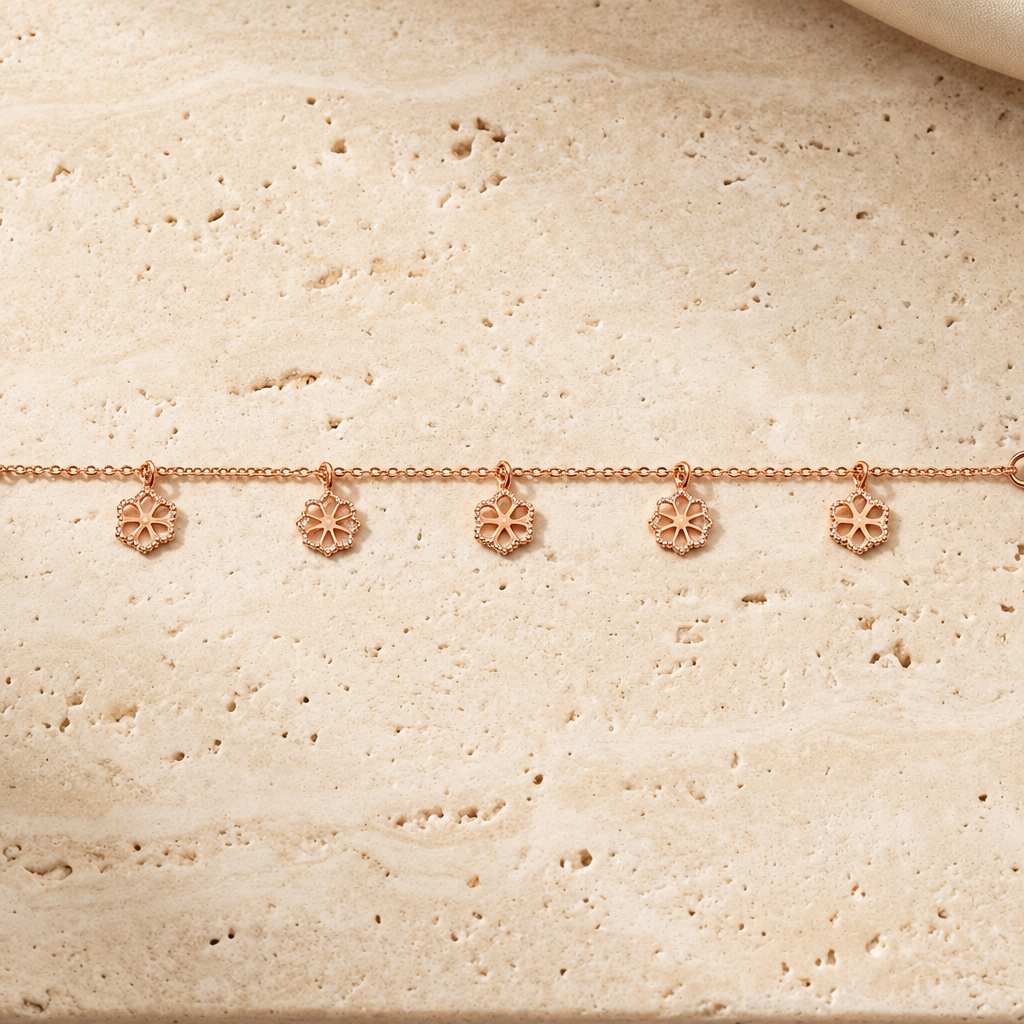 Delicate rose gold vertical chain bracelet with small flower and bead station charms priced under Rs. 35,000