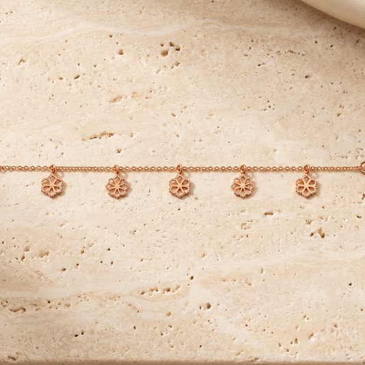Delicate rose gold vertical chain bracelet with small flower and bead station charms priced under Rs. 35,000