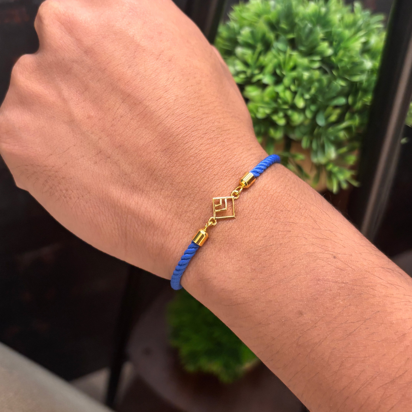 Blue rope men's gold bracelet with an 18kt gold square pattern geometric charm design. An affordable gifting option for Men's under Rs. 10,000