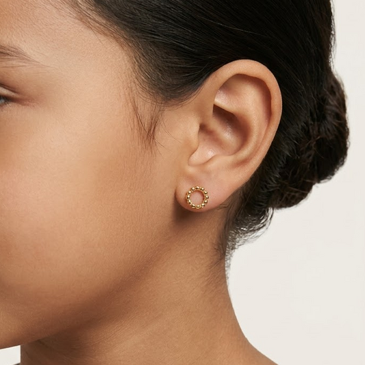 Gold stud earrings formed from a ring of small polished gold beads. Priced under Rs. 25,000