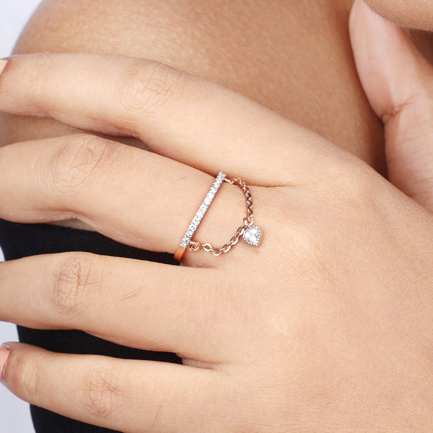 Caratly 18kt gold Dangling Diamond Ring featuring a straight pave diamond band with an attached draped chain holding a tiny diamond heart charm under Rs. 50,000