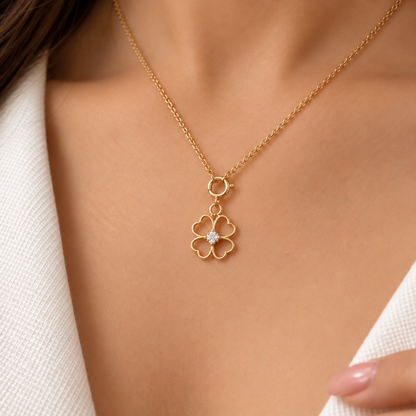 Gold four-petal clover pendant outlined in gold with a diamond-set centre. Minimal gifts for her under Rs. 15,000