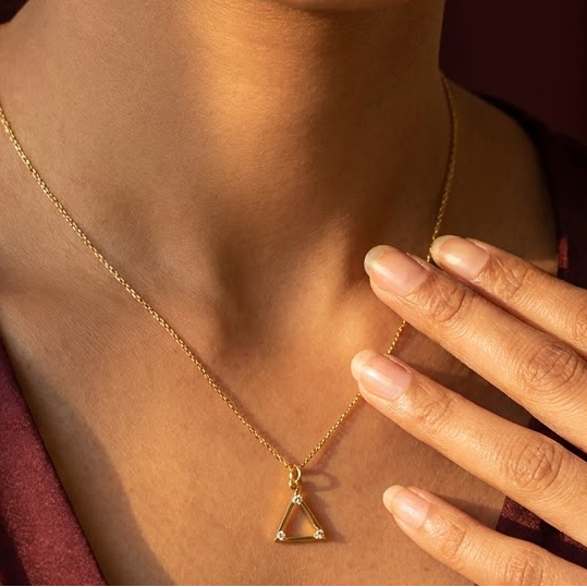 Gold triangle pendant outlined with sparkling diamond accents under Rs. 15,000