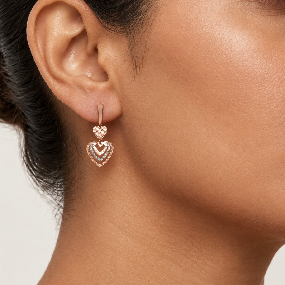 Rose-gold layered heart drop earrings with a textured top heart and pavé heart below. Luxe gold gifts for her under Rs. 80,000