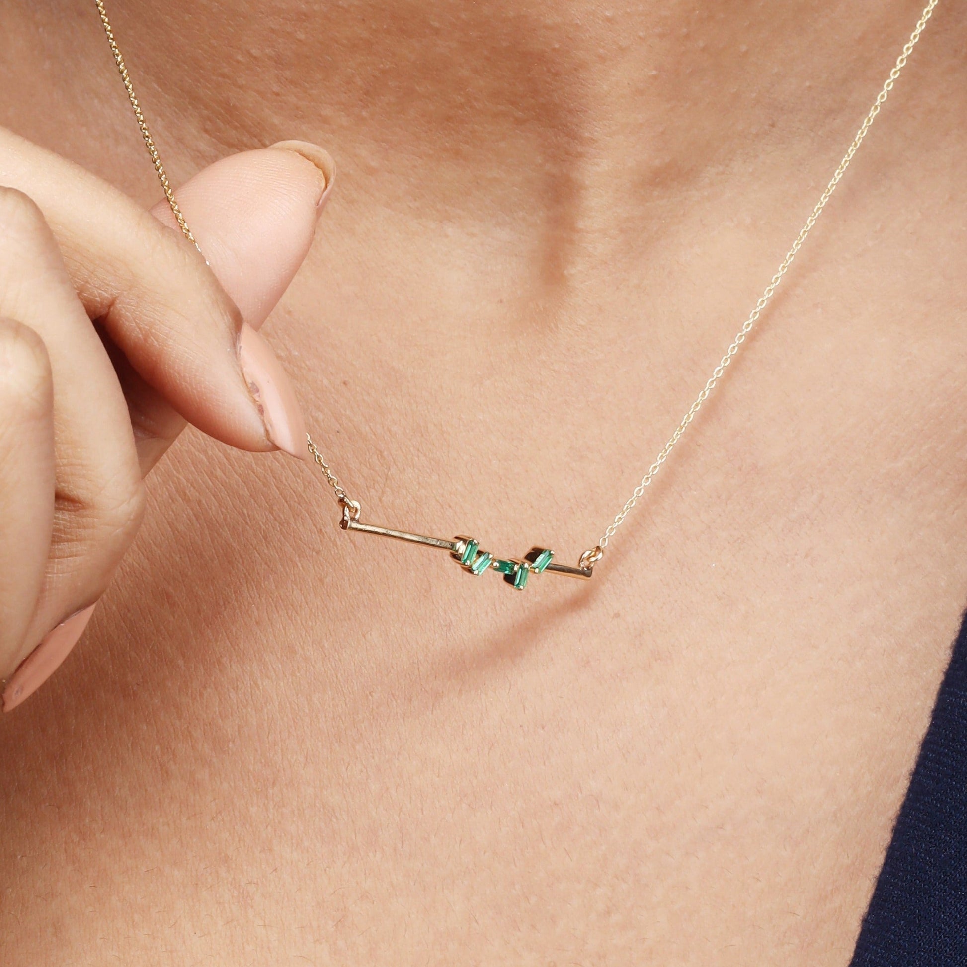 Caratly 18kt gold Baguette Emerald Necklace featuring scattered green baguette-cut emeralds on a horizontal gold bar pendant with attached chain under Rs. 40,000
