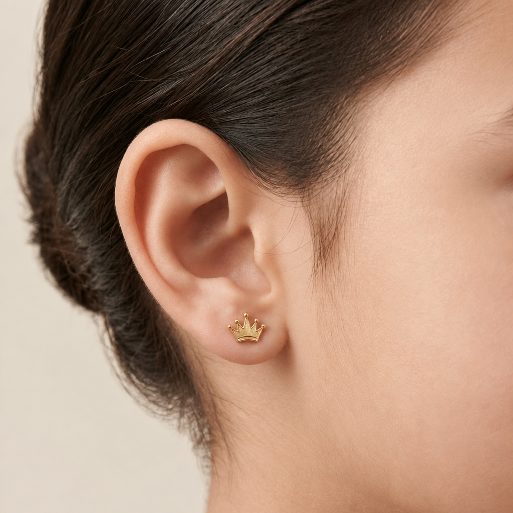 Gold crown-shaped stud earrings with a ridged, fan-textured surface. A perfect minimal gift for kids under Rs. 20,000 