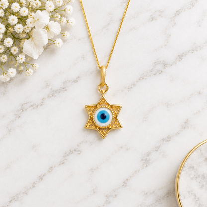 Gold star-shaped pendant framing a blue and white enamel evil eye