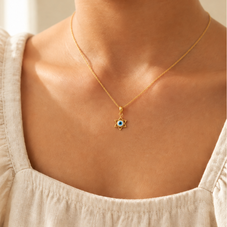Gold star-shaped pendant framing a blue and white enamel evil eye