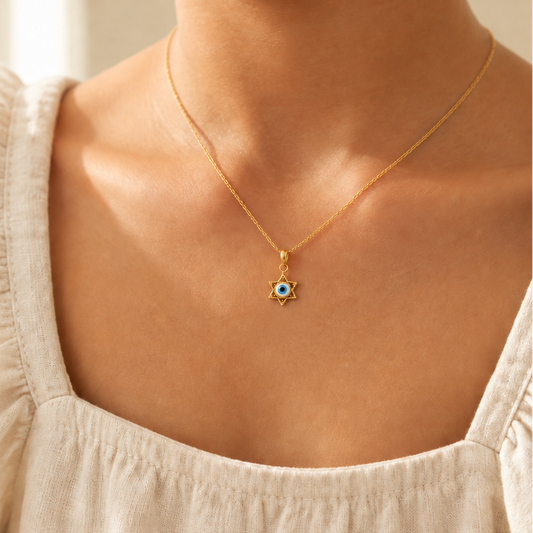 Gold star-shaped pendant framing a blue and white enamel evil eye