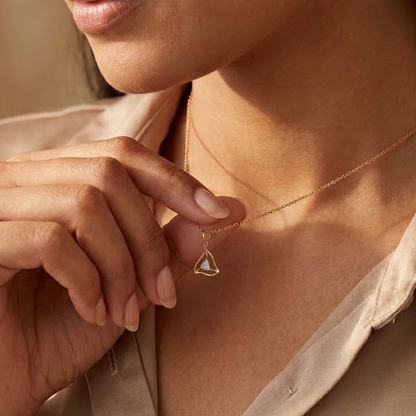 Gold swirled triangle pendant on a chain, set with sparkling diamond accents priced under Rs. 20,000